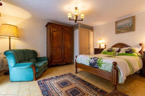 a bedroom with a bed and a blue chair and a chair sqor at Georgeluc in Langeron