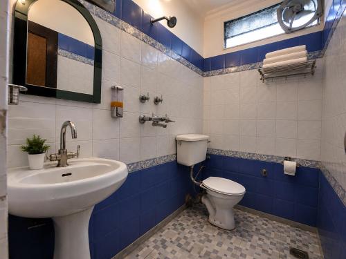 a blue and white bathroom with a toilet and a sink at Hotel Arina in Chandīgarh