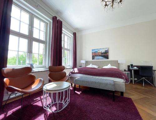 a bedroom with a bed and two chairs and a table at Hotel Wagner im Dammtorpalais in Hamburg