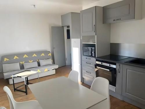 a kitchen with a table and chairs in a room at Tout confort T2 in La Bourboule