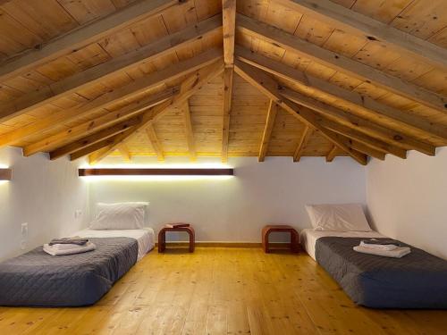two beds in a room with wooden ceilings at Faos residence I in Pefkias