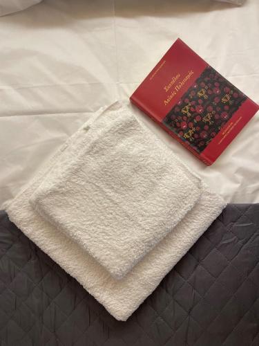 a white towel and a book on a bed at Faos residence I in Pefkias