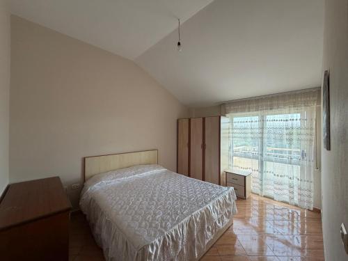 a bedroom with a bed and a large window at Apartament Golem in Golem