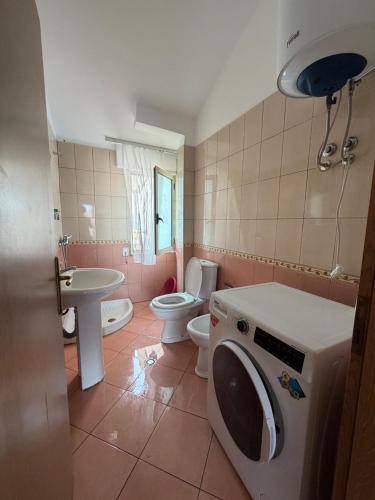 a bathroom with a washing machine and a toilet at Apartament Golem in Golem