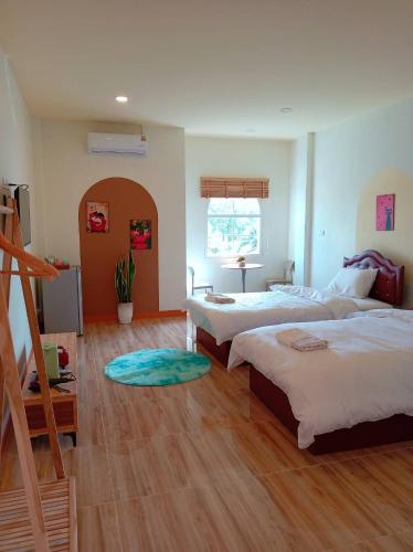 a bedroom with two beds and a wooden floor at โรงแรม JP Lucky Lux Hotel in Ban Nong Samran