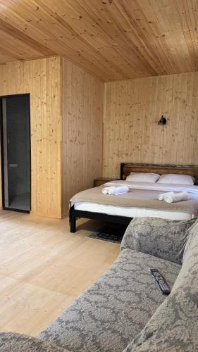 a bedroom with two beds and a wooden wall at Ord INN in Oni