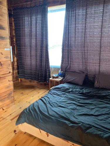 a bedroom with a bed and a large window at Thông house 2 in Kon Von Kla