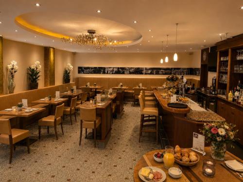 a restaurant with wooden tables and chairs and a bar at Hotel Garni Italia in Bühl