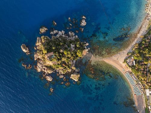eine Luftaufnahme einer Felseninsel im Wasser in der Unterkunft La Plage Resort in Taormina