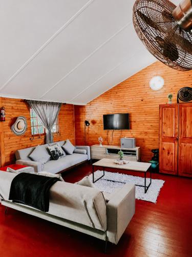 a living room with two couches and a flat screen tv at Mike's Lodge Sodwana Bay in Sodwana Bay