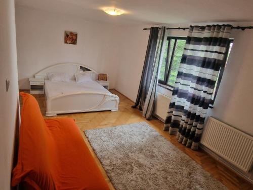 a bedroom with a white bed and a window at Casa Ursilor in Predeal