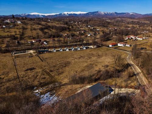 an aerial view of a town in a field with a train at Mălinului Resort and Spa in Bughea de Sus