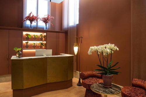 a lobby with a reception desk with chairs and flowers at Palazzo De Polo in Venice