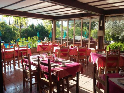 Un restaurante con mesas y sillas con mantel rojo. en Residence Concaverde, en Pomarolo