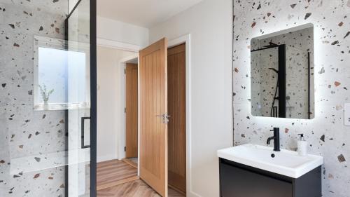 a bathroom with a sink and a mirror at Birch Tree Lodge - Luxurious Lodge on the NC500 by Thrumster Lodges in Wick