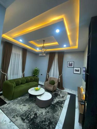 a living room with a green couch and a table at Classy Castle Hotel And Suite in Ughelli