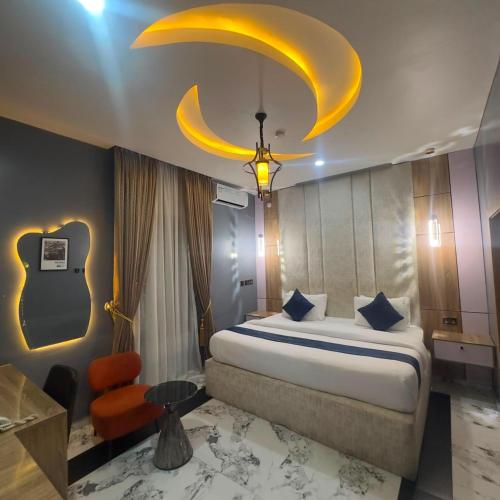 a bedroom with a large bed with a yellow ceiling at Classy Castle Hotel And Suite in Ughelli