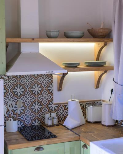 a kitchen with a stove and some plates and bowls at Eleon Olive Retreat - Skourochori in Katakolo