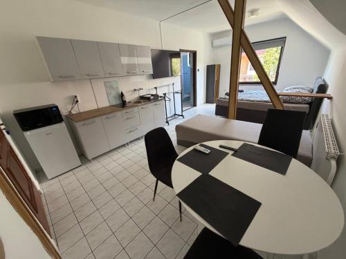 a kitchen and living room with a table and chairs at Dózsa Vendégház in Balatonboglár