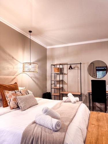 a bedroom with a large bed with towels on it at Die Boord Guesthouse in Crocodile Valley Estates