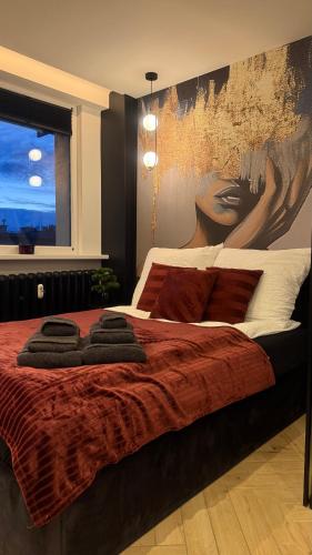 a bedroom with a bed with a painting on the wall at Apartament Centrum Ligota in Katowice