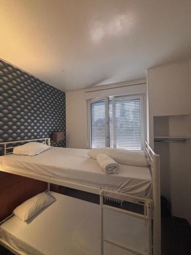 a bedroom with a large bed with two windows at Hôtel Astrid in Rouen