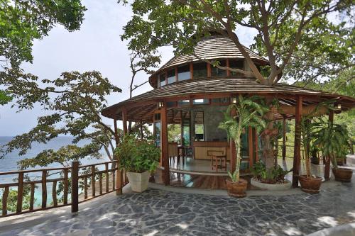 a wooden house with a tree in front of it at Sai Daeng Resort in Koh Tao