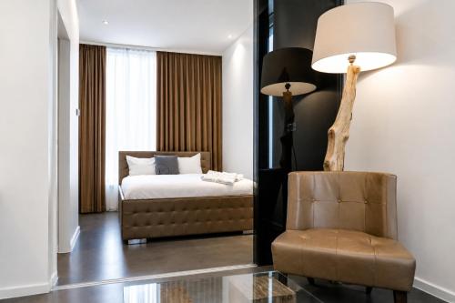 a bedroom with a bed and a chair and a lamp at VISIONAPARTMENTS Berlin - self check-in in Berlin