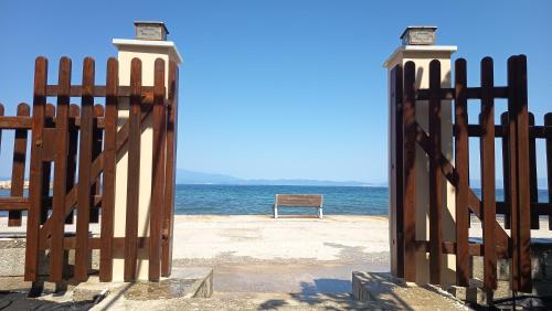 a gate on a beach with the ocean behind it at Antonia's house on the beach in Skala Sotiros