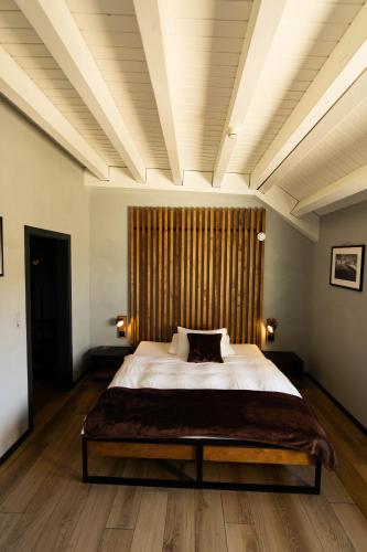a bedroom with a large bed with a wooden headboard at Alaïa Lodge in Crans-Montana