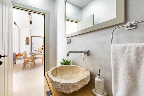 a bathroom with a stone sink and a mirror at Villa Luna Bodrum, Özel Isıtmalı Havuzlu in Ortakent