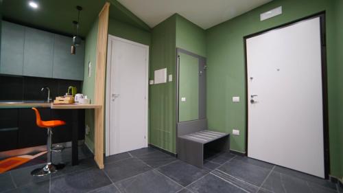 a kitchen with green and white walls and a stool at Didinas room in Potenza