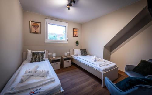 a room with two beds and a couch and a window at Diófa Vendégház in Békésszentandrás