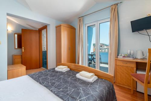 a bedroom with a bed and a balcony at Villa Ani in Trogir