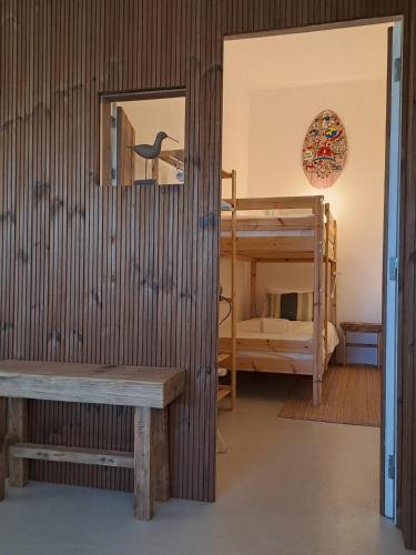 a room with a bench and a bunk bed at Casa Atlântico Carvalhal Comporta, apartamento piscina aquecida in Carvalhal