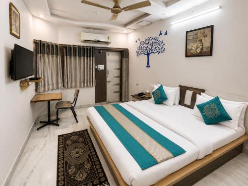 a bedroom with a bed with a desk and a television at Home Stay Inn 5 min from Sardar Vallabhbhai Patel International Airport Ahmedabad in Ahmedabad