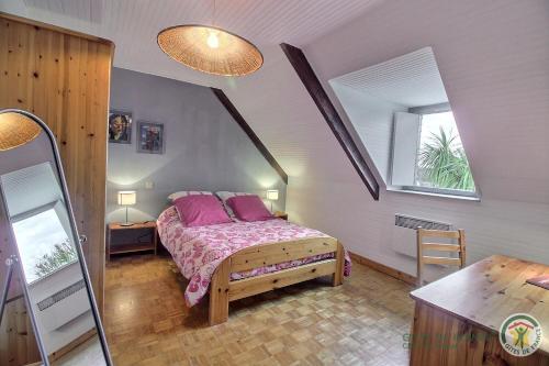a bedroom with a bed with pink pillows at Les hauts de kergiquel in Paimpol
