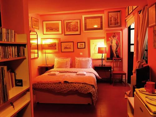 a bedroom with a bed and some pictures on the wall at Gallery Basement in Villa Vravrona in Markopoulo