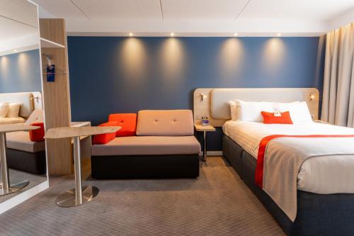 a hotel room with two beds and a chair at Holiday Inn Express Glasgow City Theatreland by IHG in Glasgow