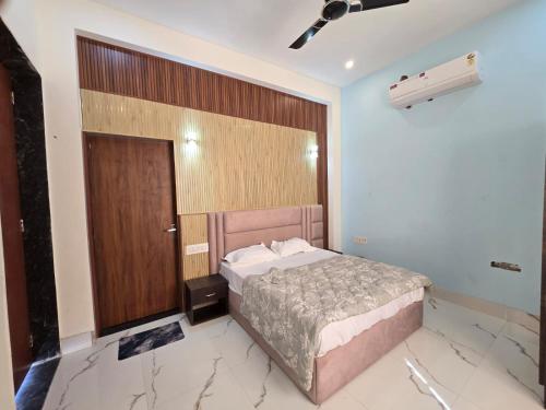 a bedroom with a bed and a wooden door at The Pool place and Restaurant in Bagar Meo