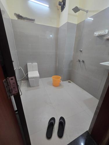 a bathroom with a shower and two shoes on the floor at The Pool place and Restaurant in Bagar Meo