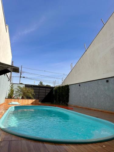 a large blue swimming pool on a wooden deck at Área de Lazer DAY USE - Chácara do Danilo in Maringá