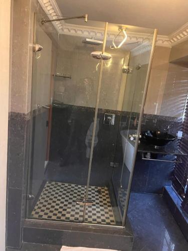 a shower with a glass door in a bathroom at SkyWags Guest House in Bloemfontein