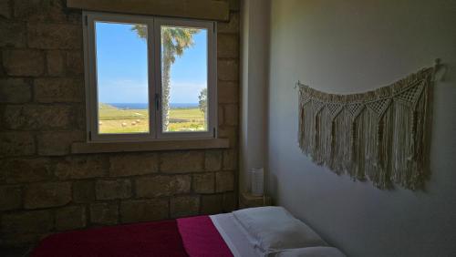a bedroom with a bed and a window with a view at Antica dimora "Nicole e Cristiano" in Otranto