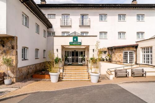 a hotel with stairs leading to the front entrance at Airport Inn Manchester in Wilmslow