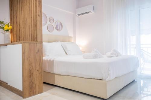 a bedroom with a large white bed with white sheets at Rafaela Sea Gem in Loutraki