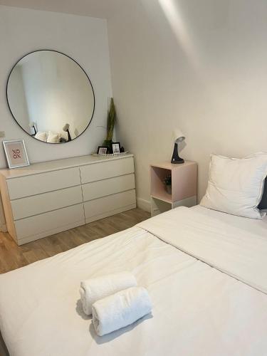 a bedroom with a white bed with a large mirror at Appartement familial RDC in Boulogne-Billancourt