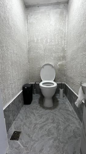 ein Badezimmer mit einer weißen Toilette in einem Zimmer in der Unterkunft KölToo in Barskoon