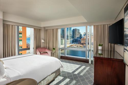 a hotel room with a bed and a large window at InterContinental Boston by IHG in Boston