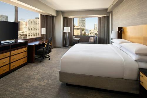 a hotel room with a bed and a desk and a television at San Francisco Marriott Union Square in San Francisco